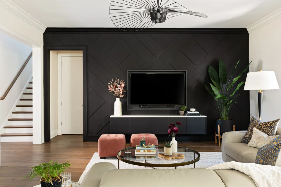 Family room with a black chevron-paneled media wall and blush velvet ottomans at Snell Isle, St. Petersburg, interior design by MJ Designs